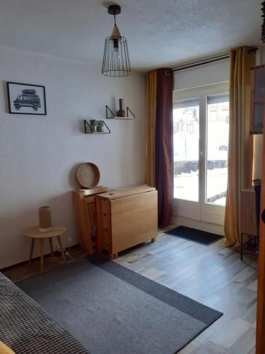 a bedroom with a bed and a dresser and a window at Studio montagne in Mijoux