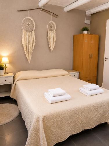 a bedroom with a bed with two towels on it at Armonía y plenitud in Trelew