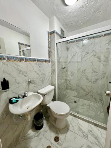 a bathroom with a toilet and a sink and a shower at Coral Suite Excellent location in Porlamar