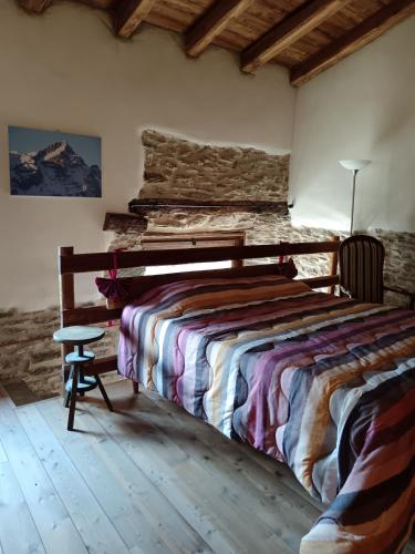 a bedroom with a bed and a stone wall at Casa delle Rose - Marmora in Marmora