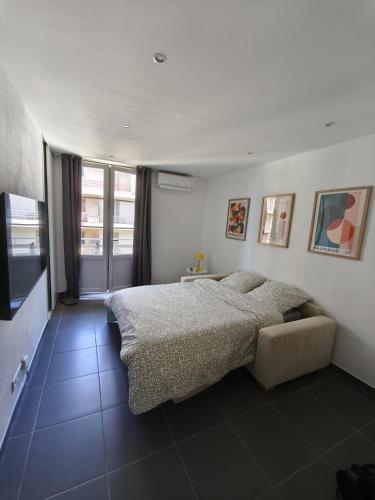 a bedroom with a large bed and a couch at Joli T1 bis - Centre ville in Bastia