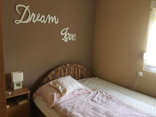 a bedroom with a bed with a dream big sign on the wall at Lena Lodge in Fonyód