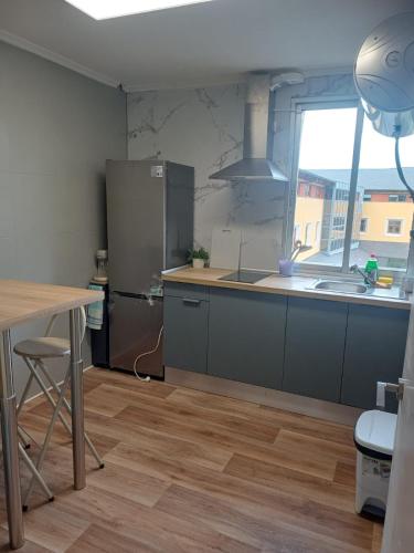 a kitchen with a stainless steel refrigerator and a table at Estafeta Apartament in Ponferrada