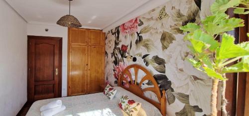 a bedroom with a wall with a floral wallpaper at COSMA HOUSE in Hinojedo