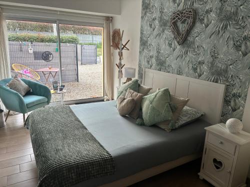 a bedroom with a bed with a chair and a window at La Carola in Bordeaux-Saint-Clair