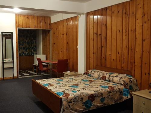 a bedroom with a bed and a table in a room at Rittoo Complex -Gavnor in Quatre Bornes