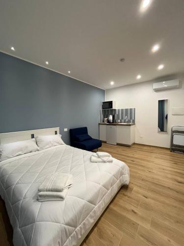 a bedroom with a large white bed and a blue chair at The Family Rooms, Rione alto, Zona ospedaliera in Naples
