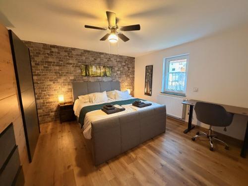 a bedroom with a bed and a ceiling fan at Ferienhaus mit Whirlpool, Garten und großer Terrasse ruhig privat in Herbstein