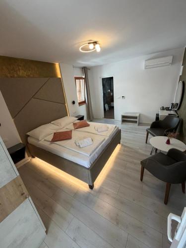 a large bedroom with a large bed and a chair at H&H Rooms Rovinj - Adults Only in Rovinj
