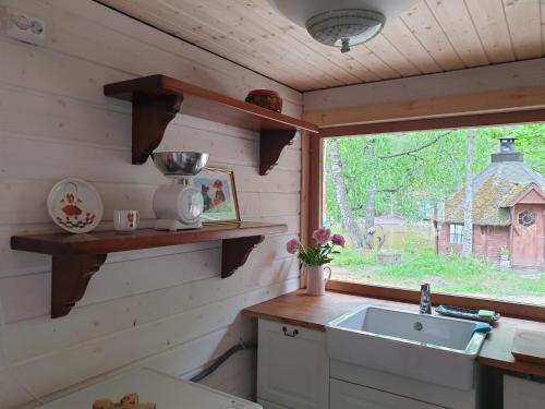 a kitchen with a sink and a window at Saunatie in Taipalsaari