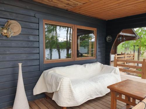 a bedroom with a bed and a window on a deck at Saunatie in Taipalsaari