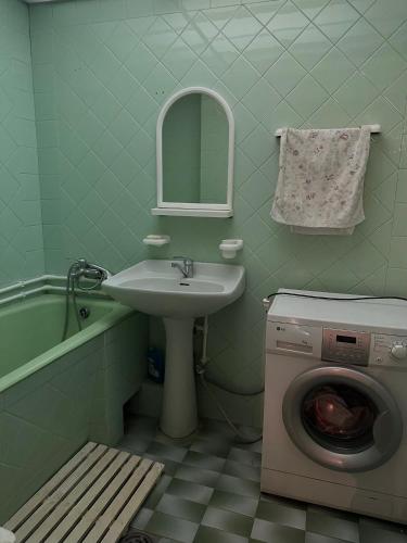 a bathroom with a sink and a washing machine at Tumo cozy corner in Yerevan