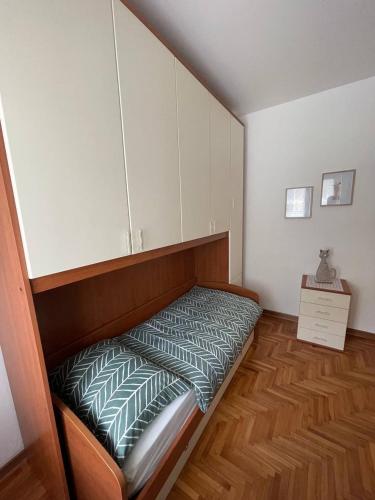 a small bedroom with a bed and a wooden floor at Ginkgo Tree Refuge in Pontebba