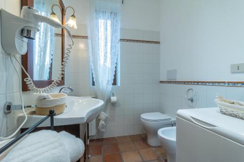 a white bathroom with a sink and a toilet at Ai due Cedri Appartamento Nocciolo in Capranica