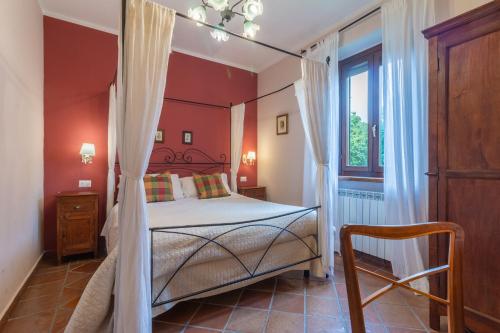 a bedroom with a canopy bed and a window at Ai due Cedri Appartamento Nocciolo in Capranica