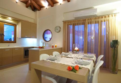 a kitchen and dining room with a table and chairs at Leste Luxury Homes in Plaka