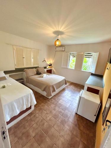 a bedroom with two beds and two windows at Barra lounge in Maragogi