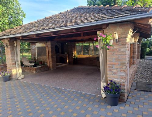 a stone pavilion with flowers in the middle at Apartman Vučedolski san in Vukovar