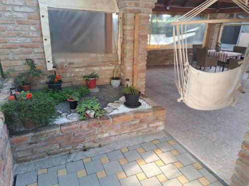 a patio with potted plants and a hammock at Apartman Vučedolski san in Vukovar