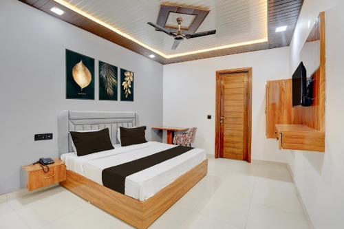 a bedroom with a bed and a television and a ceiling at Townhouse Tuessday Suites Nearst Mr Bhatura Bala Sector 122 in Noida