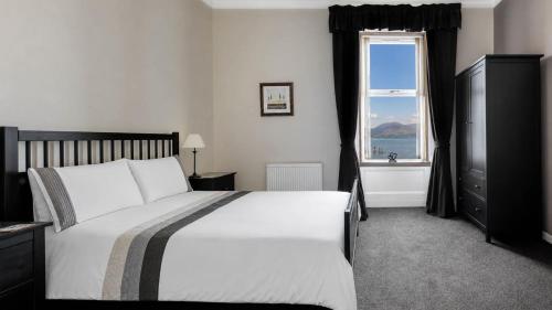 a bedroom with a large bed and a window at Ardyne House in Port Bannatyne