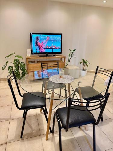 a table and chairs in a living room with a television at Verde Limon Loft (monoambiente) in San Salvador de Jujuy