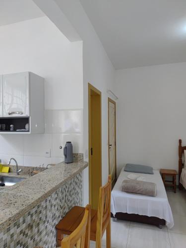 a kitchen with a bed and a counter top at Flat Alvorada in Ouro Preto