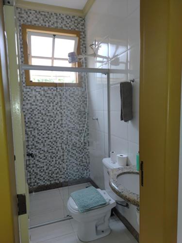 a bathroom with a shower and a toilet and a window at Flat Alvorada in Ouro Preto