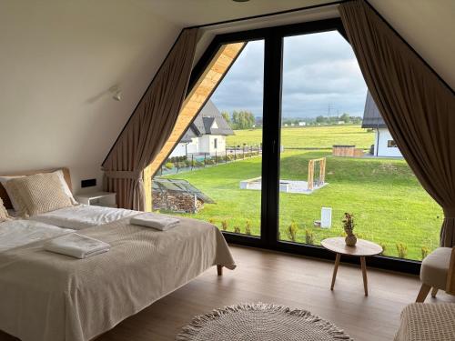 a bedroom with a large window with a view of a field at Kącik Na Dolinie in Groń