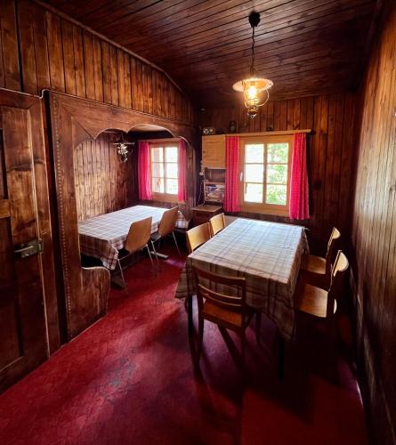 a room with two tables and chairs in a cabin at Bergunterkunft Ova Spin in Zernez