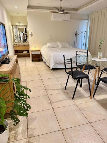a bedroom with a bed and a glass table and chairs at Verde Limon Loft (monoambiente) in San Salvador de Jujuy