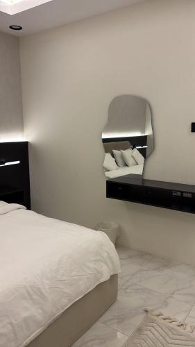 a bedroom with a bed and a mirror on the wall at نزل سوم in Hail