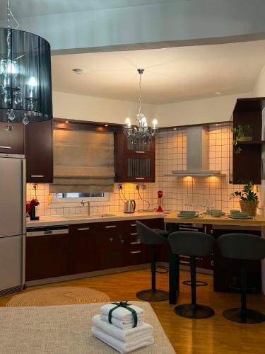 a kitchen with a table and chairs and a refrigerator at Angel's Luxury Studio in Olympiada