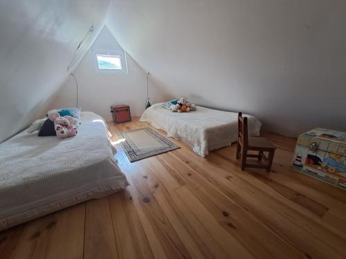 a bedroom with two beds and a wooden floor at location gite chez DENIS in Alçay-Alçabéhéty-Sunharette