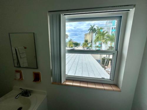 a bathroom with a window with a view of a pool at Birch Patio Motel in Fort Lauderdale