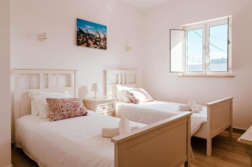 a bedroom with two beds and a window at Maria's Village in Tavira