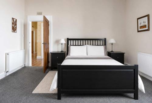 a bedroom with a black bed and two night stands at Ardyne House in Port Bannatyne