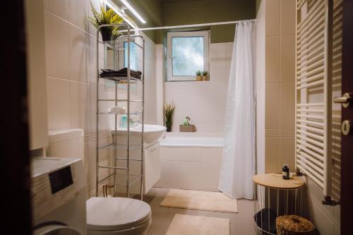 a bathroom with a toilet and a tub and a sink at Glow Central Apartment Eminescu in Târgu-Mureş