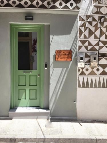 a green door on the side of a building at Mastiha Essence Residence in Pyrgi