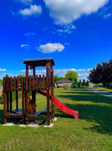 a playground with a red slide in a park at Apartmány Harmónia in Veľký Meder