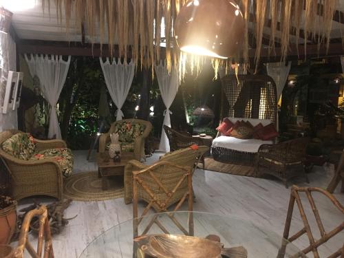 サン・ジョルジェにあるPousada Bambu Brasilのリビングルーム(籐の椅子、ソファ付)