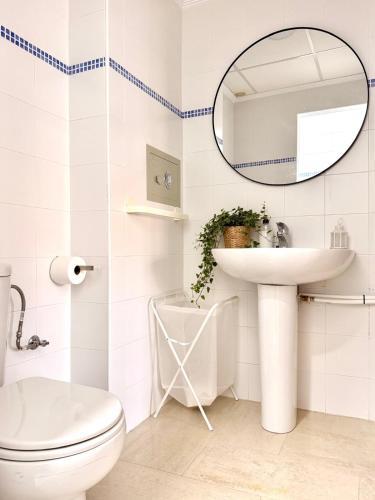 a white bathroom with a sink and a mirror at Casa Placeta Serna in Vélez-Rubio