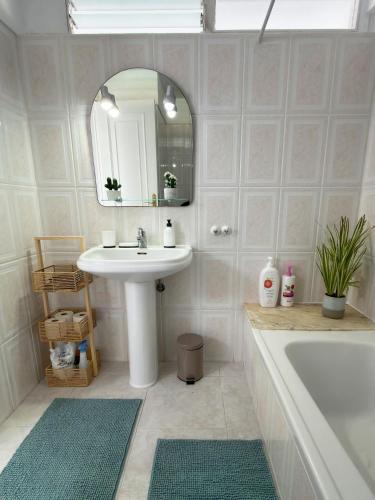 a bathroom with a sink and a mirror and a tub at Cactus Apartment in Playa Fañabe