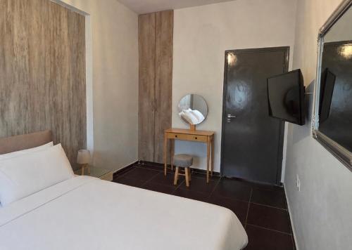 ein Hotelzimmer mit Bett und Fernseher in der Unterkunft Valla Studio in Rhodos (Stadt)