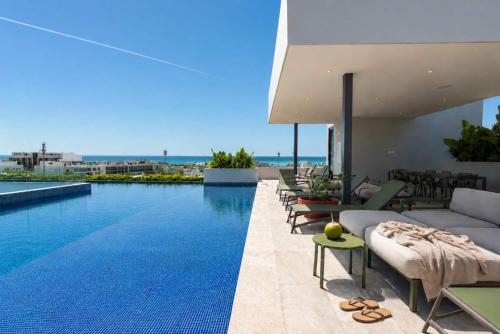 a large swimming pool with chairs and a couch at Ceiba 25 by Andiani Travel in Playa del Carmen