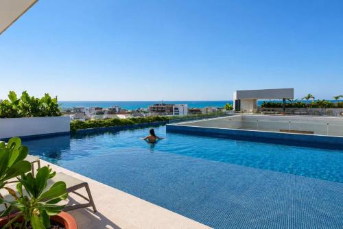 a man in a swimming pool on top of a building at Ceiba 25 by Andiani Travel in Playa del Carmen