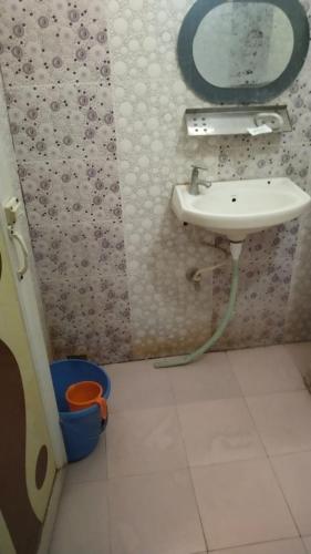 a bathroom with a sink and a mirror on the wall at Priyadarshi Hotel in New Digha