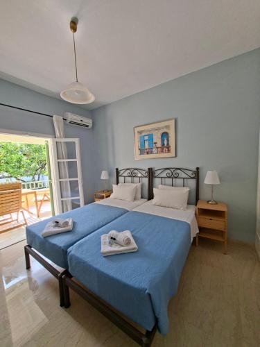 a bedroom with a large bed with towels on it at Kipos Apartments in Kassiopi