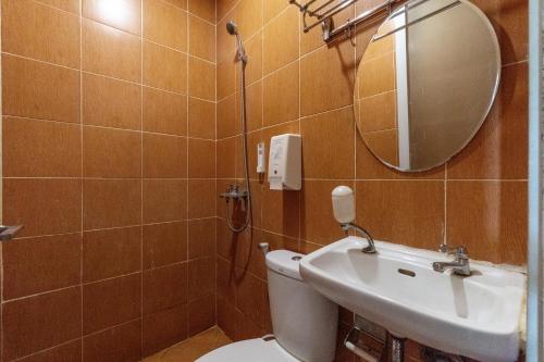 a bathroom with a toilet and a sink and a mirror at Hotel Aleander By ARBA in Jakarta