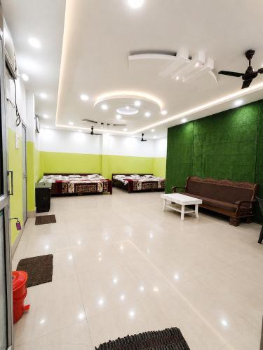 a room with three beds and a green wall at Hotel Janki Niwas - बाबा बैद्यनाथ मंदिर के निकट in Deoghar